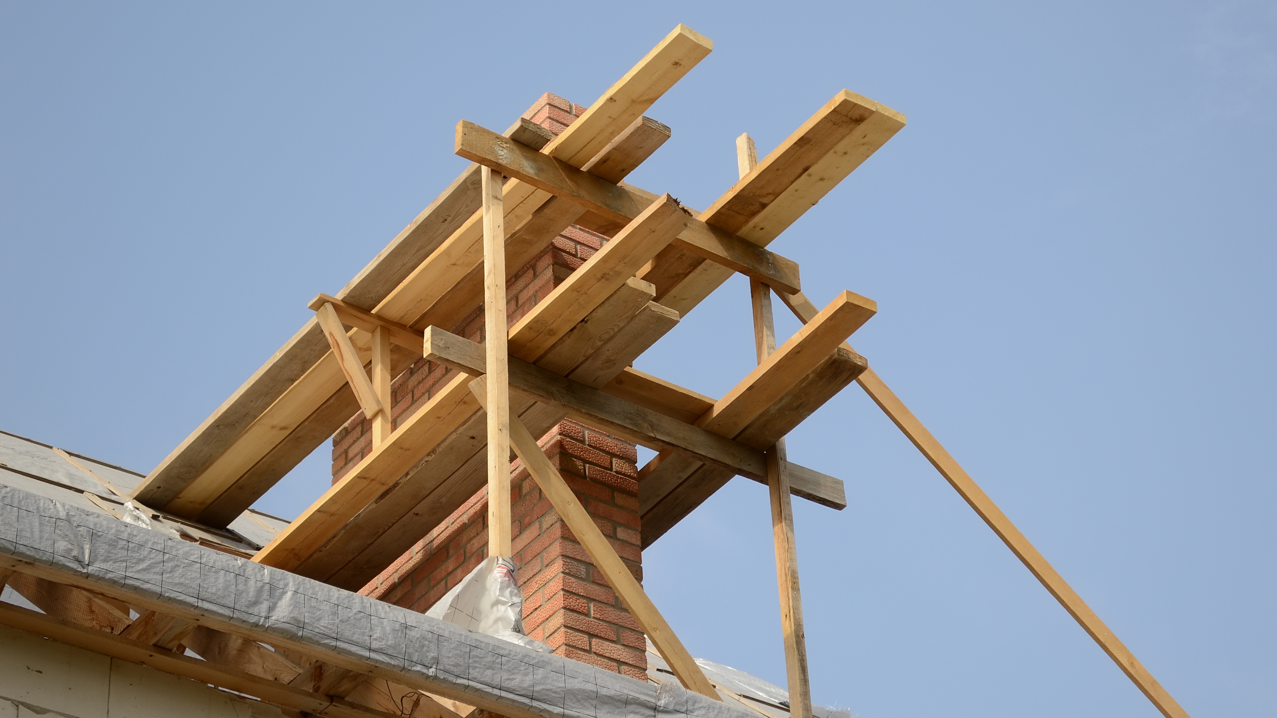 A chimney surrounded by wood scaffolding