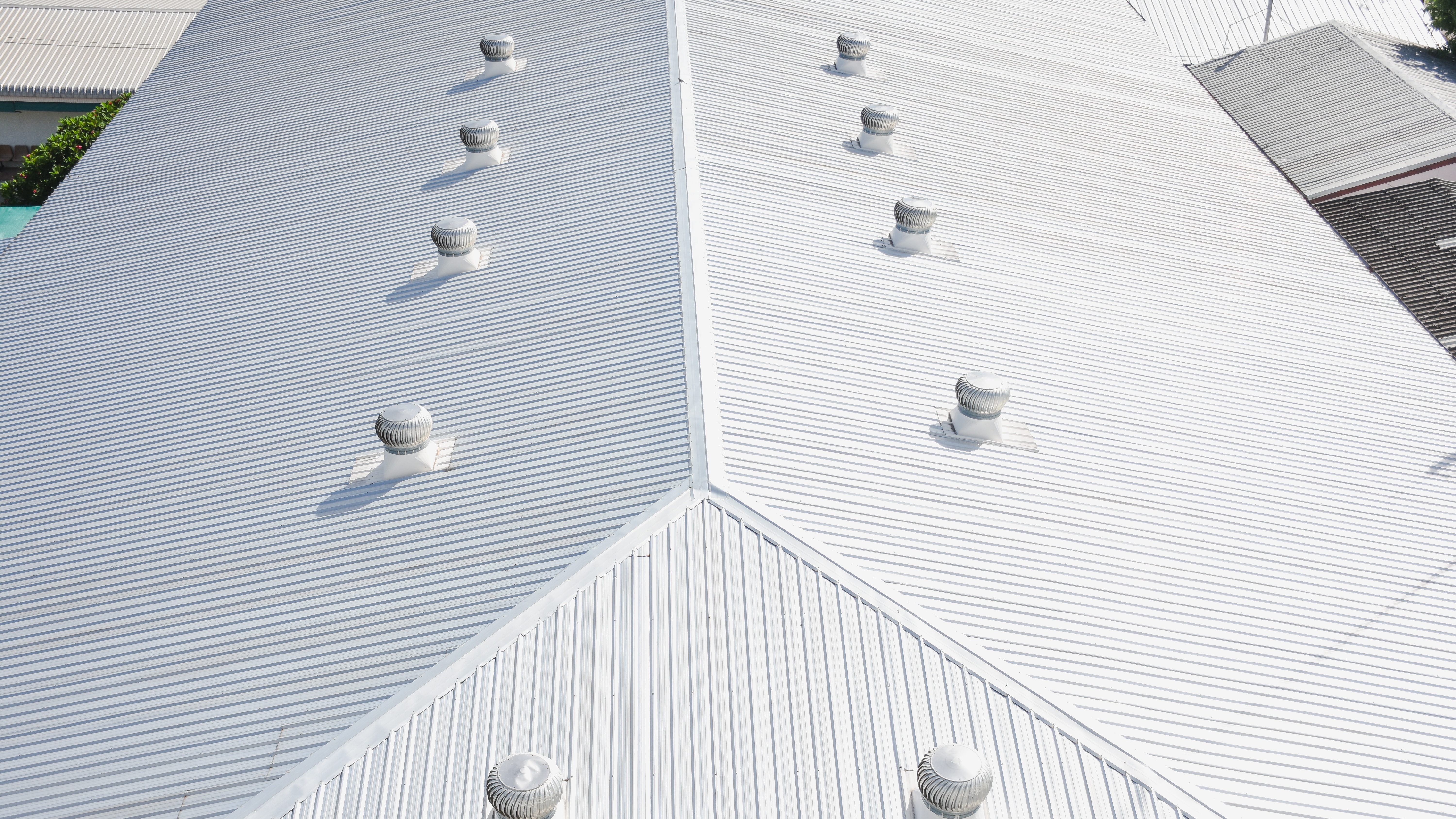 A white metal commercial roof with vents