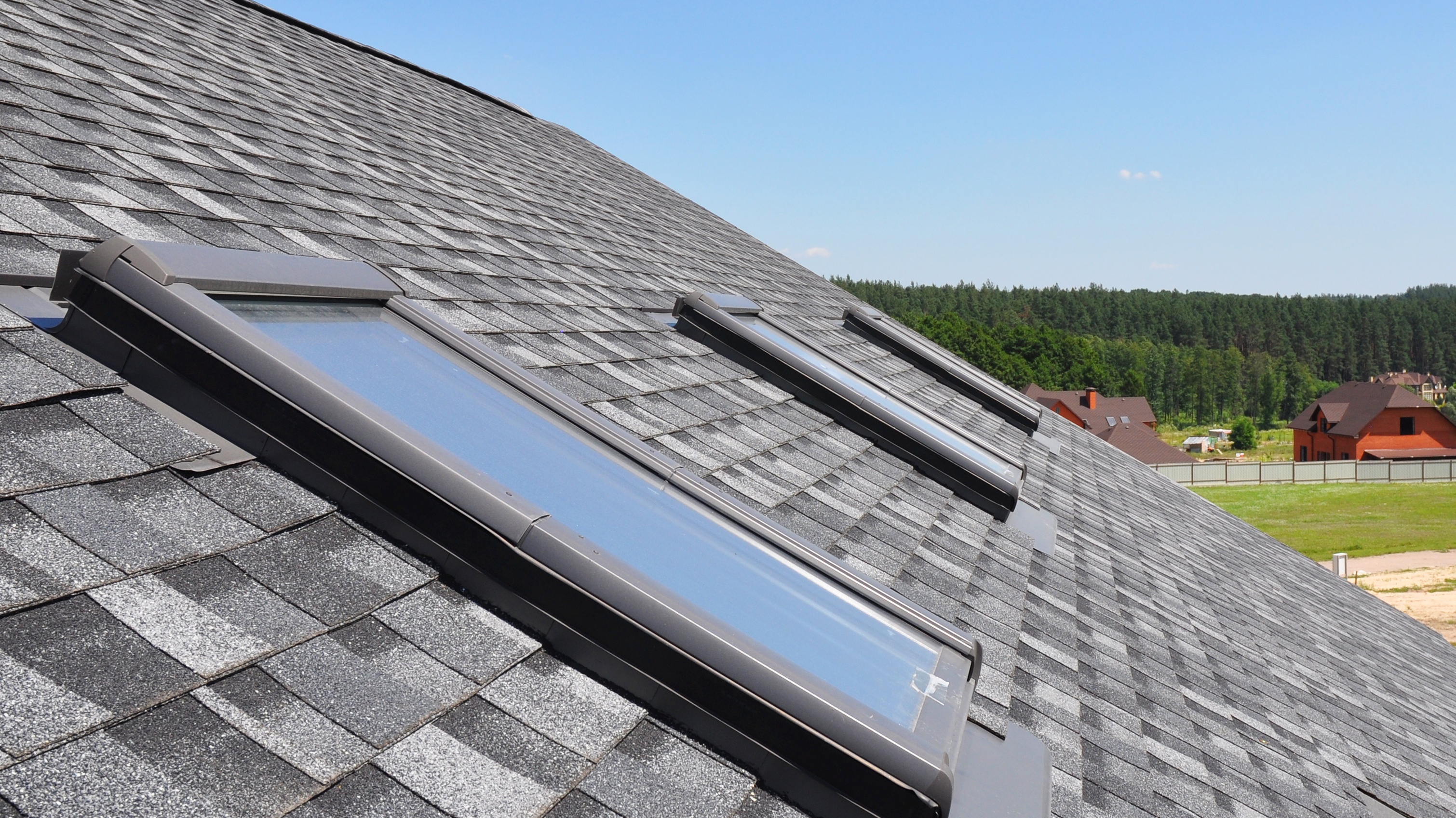 Closeup of skylights on a residential asphalt shingle roof